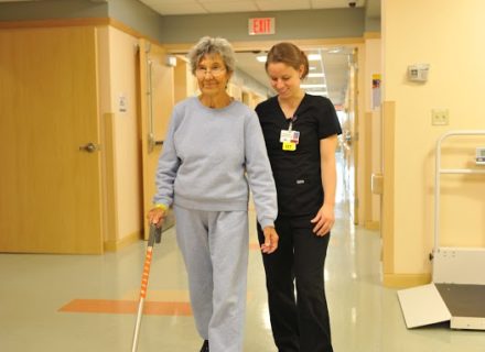 Patient walking down hall with nurse
