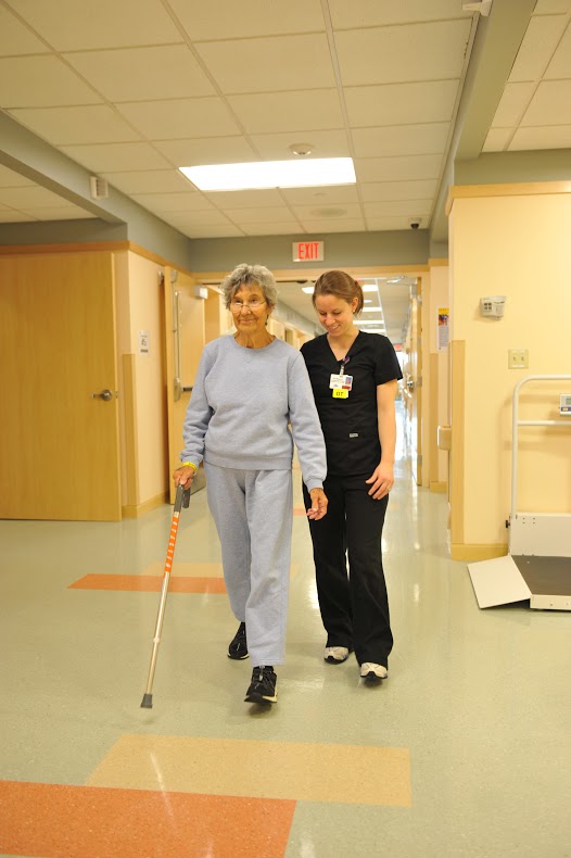 Patient walking down hall with nurse
