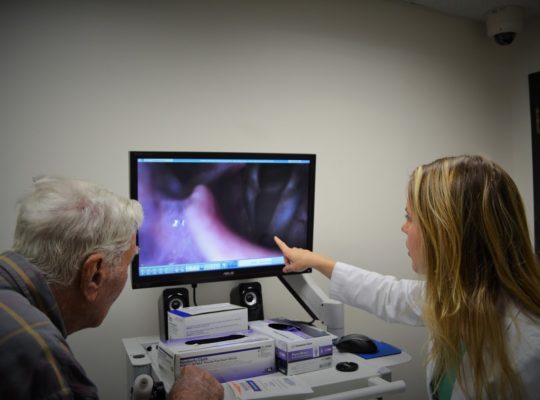 Patient looking at results of modified barium swallow study