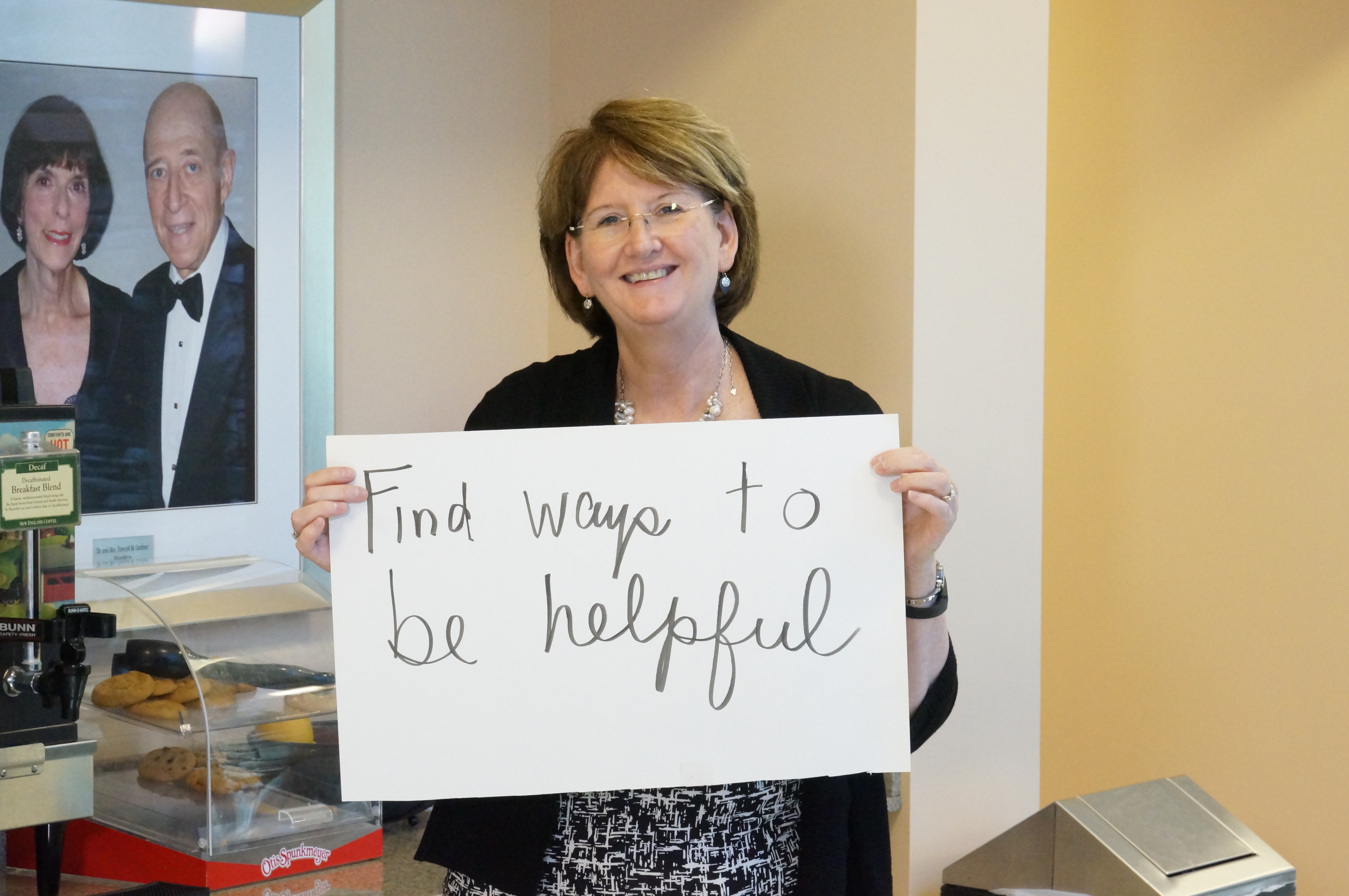 Staff holding sign Find Ways to be helpful