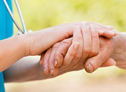 Nurse holding man's hand