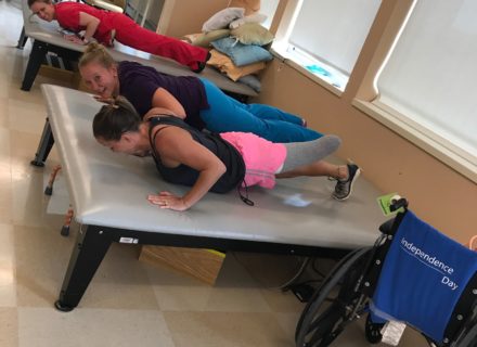 Patient doing push ups with her therapists