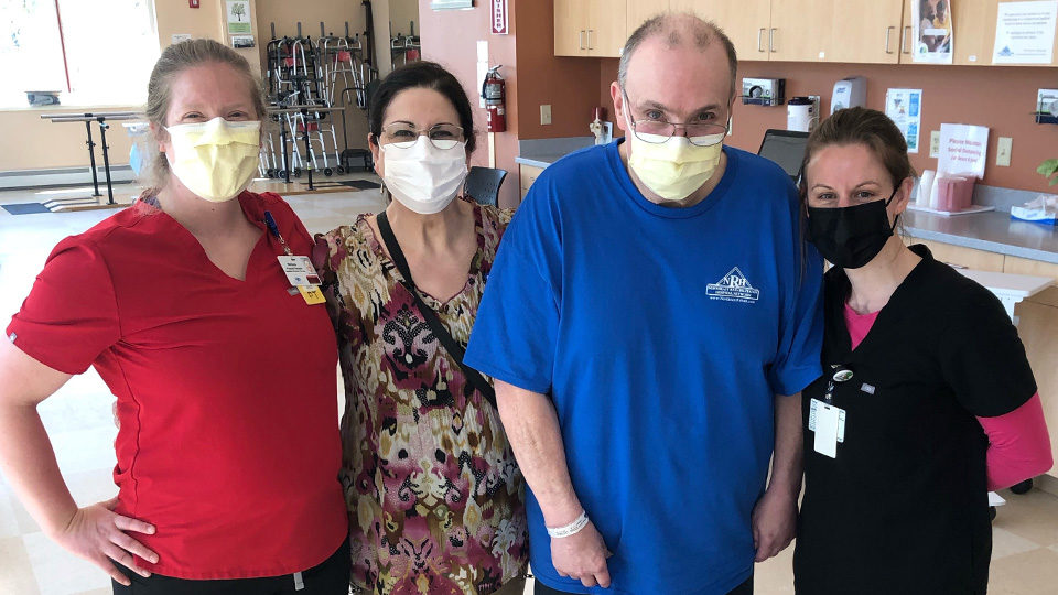 Photo of Bruce and his care team. Bruce is standing.