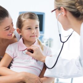 Picture of a doctor caring for a child and working with the mom.
