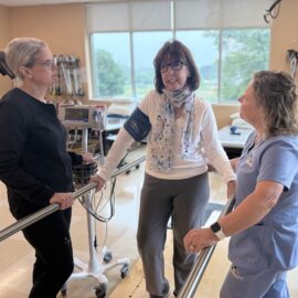 Cancer rehab care at Northeast Rehabilitation Hospital includes multidisciplinary care from Nurses, Therapists and other providers. This picture shows a nurse and physical therapist collaborating during a therapy session. 